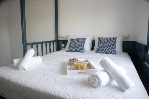 a bed with a tray of orange juice and towels at Evelia Sea House in Plimmiri