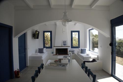 a living room with white furniture and windows at Evelia Sea House in Plimmiri