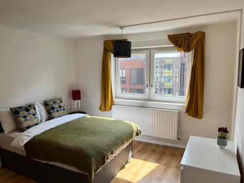 a bedroom with a bed and a window at Morden 2 bedroom Apartment tower bridge in London