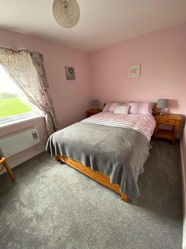 a small bedroom with a bed and a window at Moonstone in Beadnell