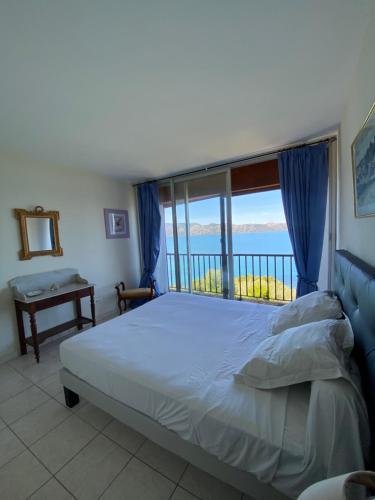 une chambre avec un lit et une grande fenêtre dans l'établissement appartement du soleil, à Patrimonio