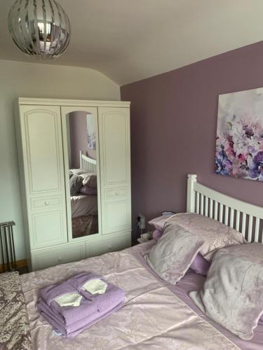 a bedroom with a bed with purple towels on it at Beautiful 2-Bed House in Larne with free parking in Larne