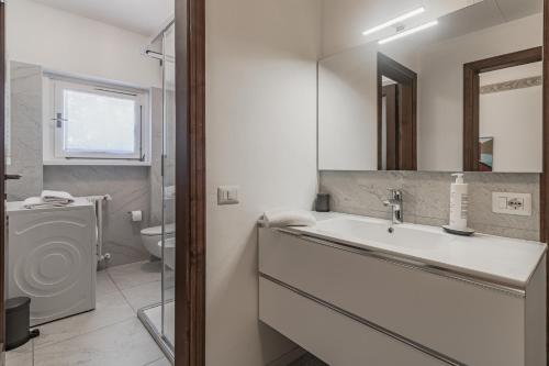 Baño blanco con lavabo y aseo en Ca' Maria Acero by Wonderful Italy, en Bellagio