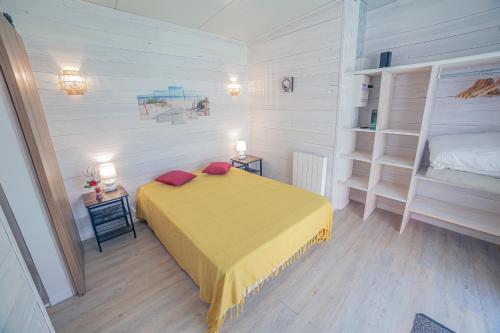 una camera con un letto giallo e due scaffali di VILLA piscine-spa-sauna, 25 personnes, 5 mn océan a Soulac-sur-Mer
