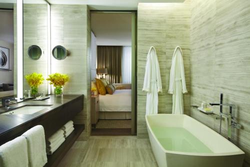 
a bathroom with a tub, sink and mirror at Four Seasons Hotel Toronto at Yorkville in Toronto
