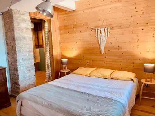 une chambre avec un lit dans une pièce en bois dans l'établissement La Guinguette de Cormatin, à Cormatin