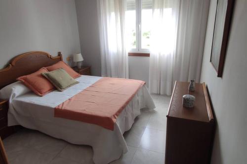 um quarto com uma cama grande e uma janela em Piso turístico Dena em Pontevedra