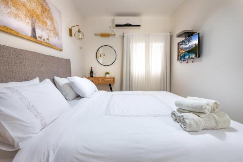 a bedroom with a white bed with towels on it at מאיה בגליל - אירוח דרוזי מושלם עם ממ"ד ובריכה מחוממת ומשותפת במתחם in Bet Dagan