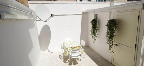 a table and chairs on a balcony with a door at Family and friends house in Lecce