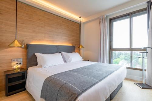 a bedroom with a large bed and a large window at Espahotel Plaza de España in Madrid