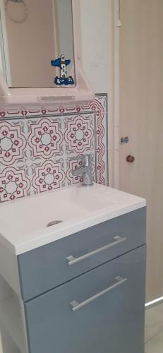 une salle de bain avec un lavabo et un miroir dans l'établissement Mobilhome emplacement 2, à Plougrescant