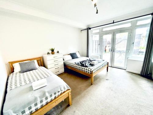 a bedroom with two beds and a window at Up to 3 people, Room in a share house with private Garden access in London