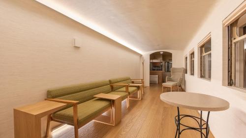 a living room with a green couch and tables at Shokudo and Hotel Kisyapoppo in Nakatsu