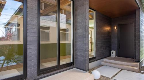 a front door of a house with glass windows at Shokudo and Hotel Kisyapoppo in Nakatsu