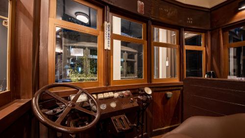 a room with a wooden steering wheel and windows at Shokudo and Hotel Kisyapoppo in Nakatsu