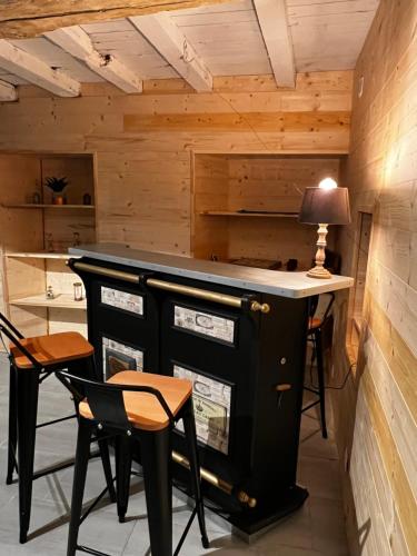 a bar in a room with two chairs and a table at Domaine de la Ville Chérel, maison en pierre in Pontorson