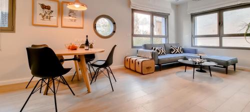 een woonkamer met een bank en een tafel en stoelen bij BnBIsrael apartments - Ness Tsiyona Cachemire in Tel Aviv