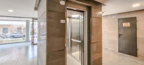 een metalen lift in een kamer met een glazen deur bij BnBIsrael apartments - Ness Tsiyona Cachemire in Tel Aviv