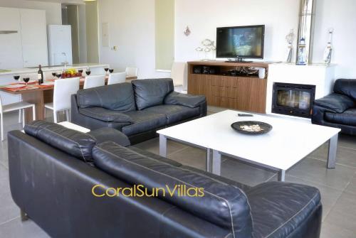 a living room with a couch and a table at Blue - Beach Front Spectacular Villa Sleeps 10 in Argaka