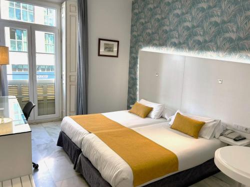 a hotel room with a bed and a bathroom at Atarazanas Málaga Boutique Hotel in Málaga