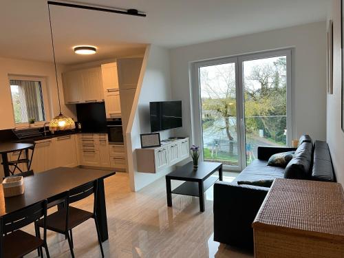 a living room with a couch and a table and a kitchen at Résidence du Golf Eselborn in Eselborn