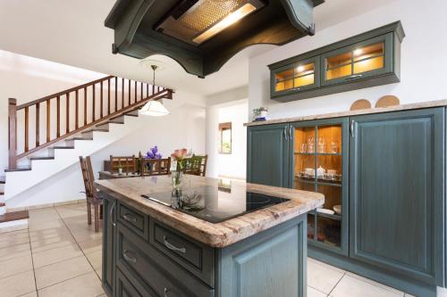 a kitchen with green cabinets and a staircase at Live Santa Úrsula Cala in Santa Úrsula