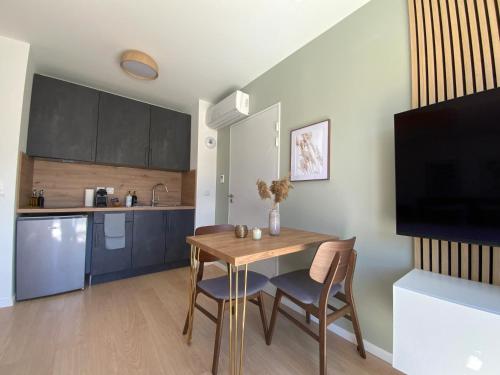a kitchen and dining room with a table and chairs at Les Loges de la Mer - Pérols in Pérols
