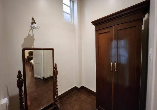 a hallway with a mirror and a wooden cabinet at Ivanhoe Hotel (A Heritage Property) in Darjeeling