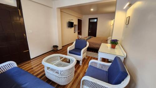 a living room with a couch and chairs in a room at Ivanhoe Hotel (A Heritage Property) in Darjeeling