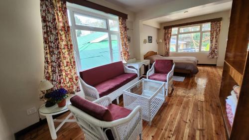 a living room with a couch and chairs and a window at Ivanhoe Hotel (A Heritage Property) in Darjeeling