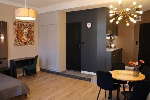 a living room with a table and a kitchen at DK Premium Warmińska Secesja in Olsztyn