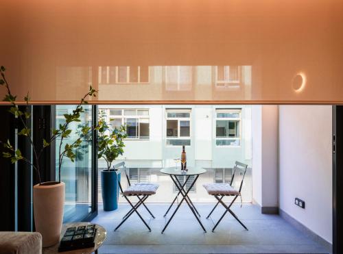 uma sala de estar com uma mesa e cadeiras num quarto em TocToc Suites Olof Palme em Las Palmas de Gran Canaria