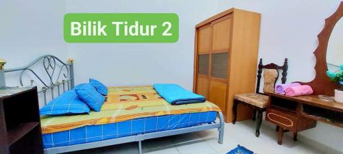 een slaapkamer met een bed, een dressoir en een bureau bij Homestay Intan Anjung Lodge in Melaka