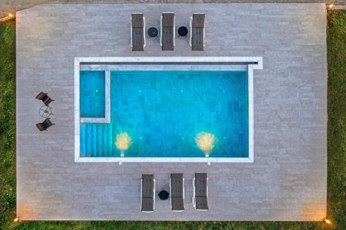 an overhead view of a swimming pool with chairs at Villa Nikoli in Kolymbia