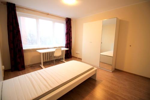 a bedroom with a bed and a desk and a window at Varpo st 10 Kaunas Students Home LT in Kaunas