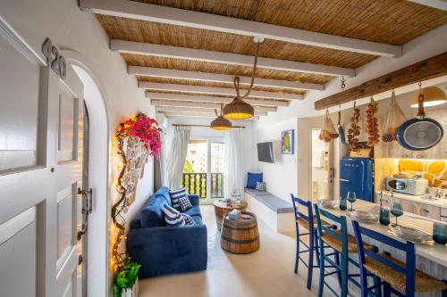 a kitchen and living room with blue chairs and a table at Castle Holiday Apartments in Limassol