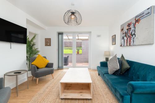 a living room with a blue couch and two chairs at Super King Bed Free Parking Alexa Garden Patio BBQ Sleeps 5 in Avonmouth