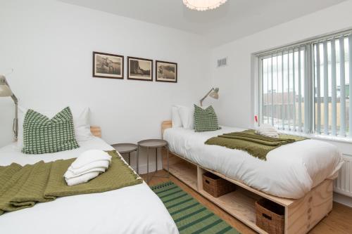 two beds in a room with a window at Brett Stays - King Weston Abode in Avonmouth