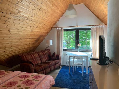 a bedroom with a bed and a table and a couch at B&B Oostkapelle aan Zee in Oostkapelle