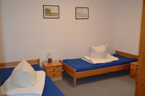 a room with two beds with blue sheets and white pillows at Haus Simone in Insel Poel