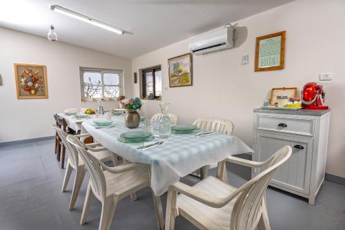 a dining room with a long table and chairs at מאיה בגליל - צימרים מקסימים עם בריכה מחוממת משותפת in Bet Dagan