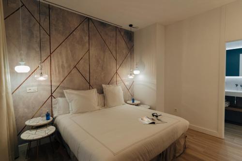 a bedroom with a large bed with a large headboard at Galmen Suites in Seville