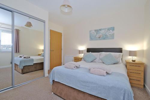 1 dormitorio con 2 camas y un espejo grande en Caledonia Netherhills Apartment en Aberdeen