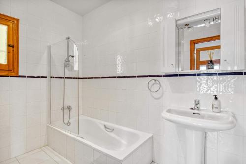 a white bathroom with a sink and a shower at Amor Supremo in Cumbre del Sol