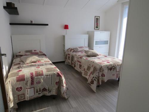 a bedroom with two beds and a mirror at CASA MICHELA BB OSSOLA PARKING FREE in Domodossola