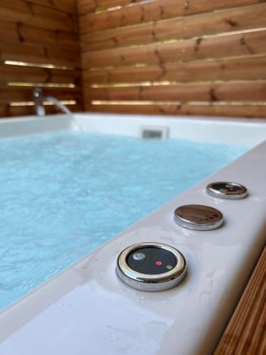 a remote control sitting on the side of a bath tub at Jacuzzi studio close to athens airport!! in Pallíni
