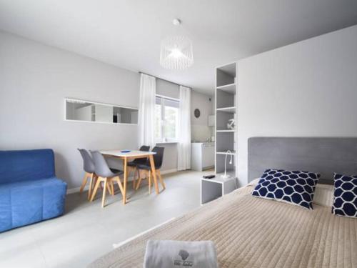 a bedroom with a blue bed and a table and chairs at Villa Sanibel in Bobolin