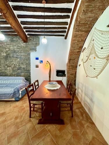 a dining room with a table and a bed at CasaCamilla in Piombino