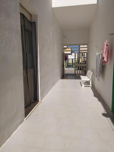 um corredor vazio com uma porta e um banco em Lucy beach em Torre Lapillo