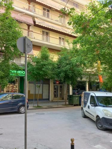 a street with cars parked in front of a building at Central 4 Modern Apartment with parking in Serres
